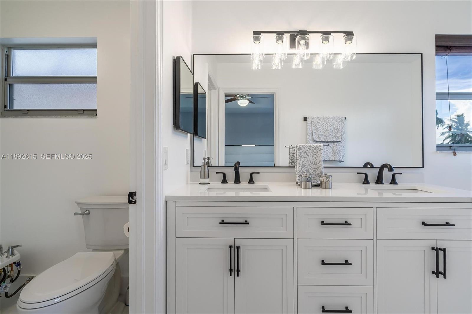 15025 Southwest 141st Terrace Miami, FL 33196 - Photo 14 of 34 a bathroom with a sink vanity mirror and toilet