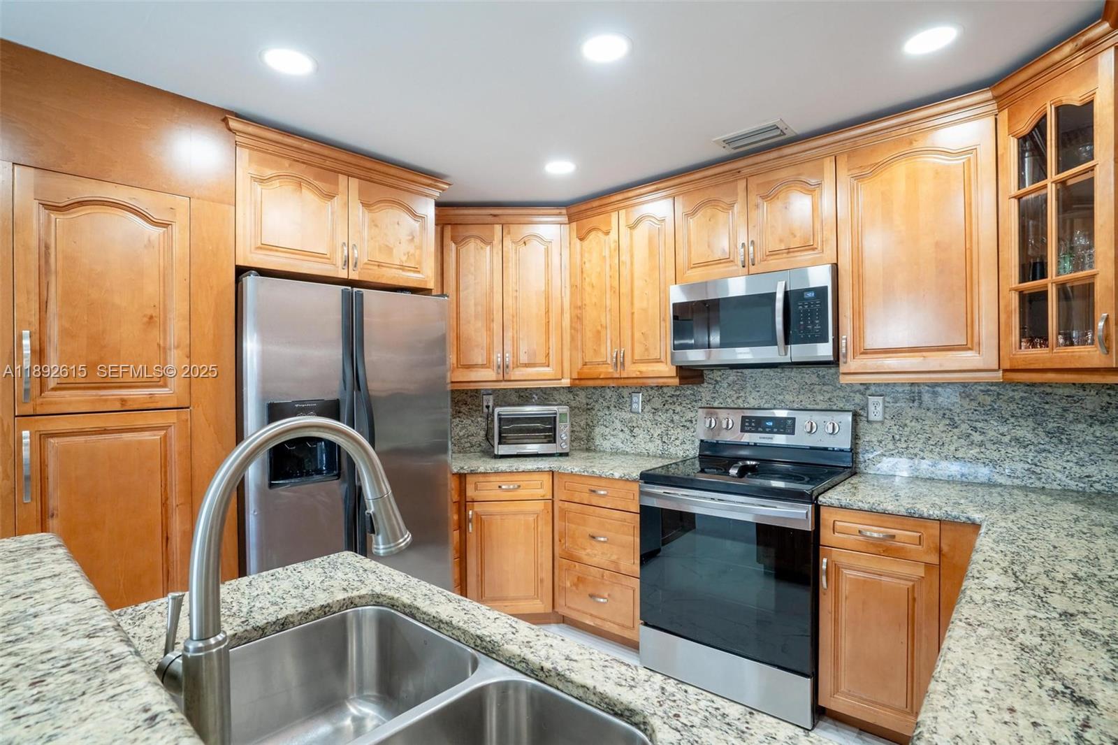 15025 Southwest 141st Terrace Miami, FL 33196 - Photo 2 of 34 a kitchen with stainless steel appliances granite countertop a sink a stove a refrigerator cabinets and a large window