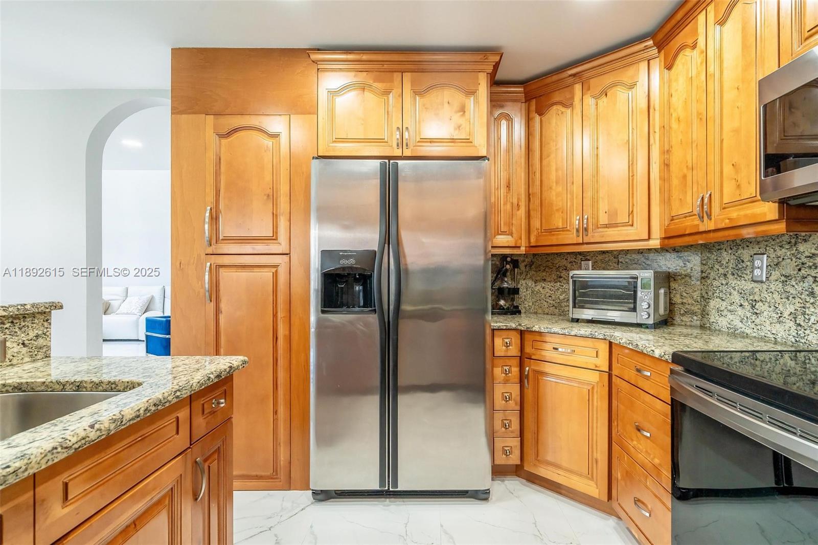 15025 Southwest 141st Terrace Miami, FL 33196 - Photo 4 of 34 a kitchen with granite countertop a refrigerator and a sink