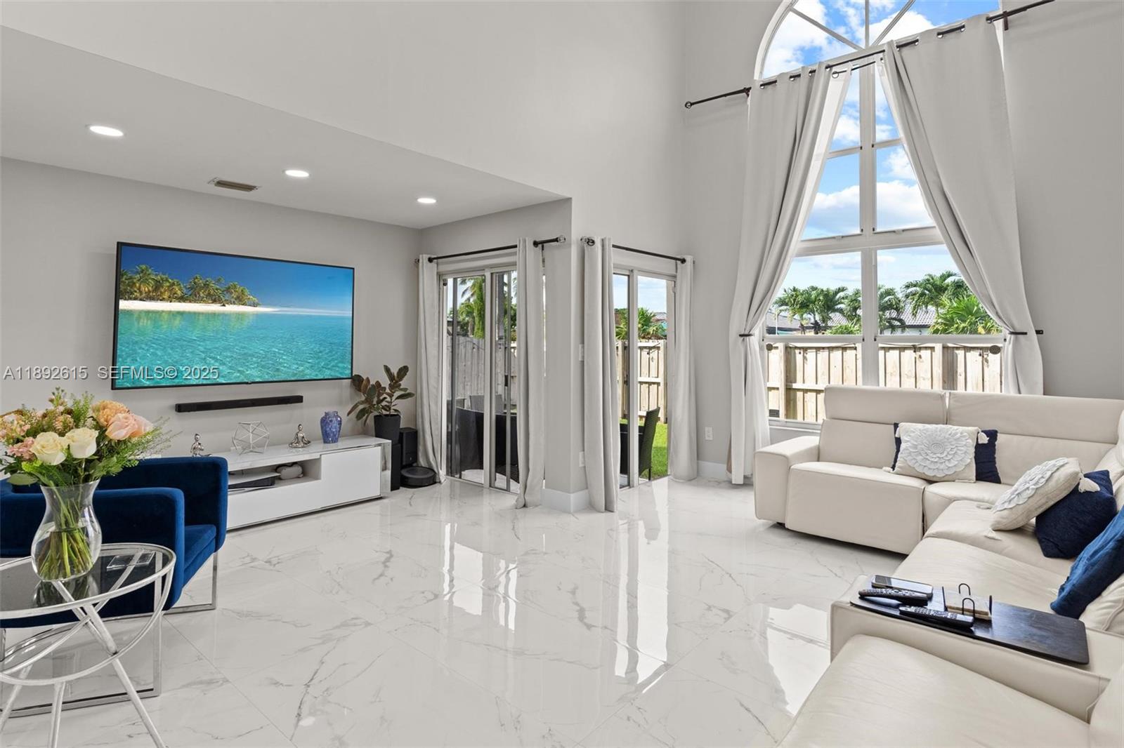 15025 Southwest 141st Terrace Miami, FL 33196 - Photo 5 of 34 a living room with furniture a flat screen tv and a large window