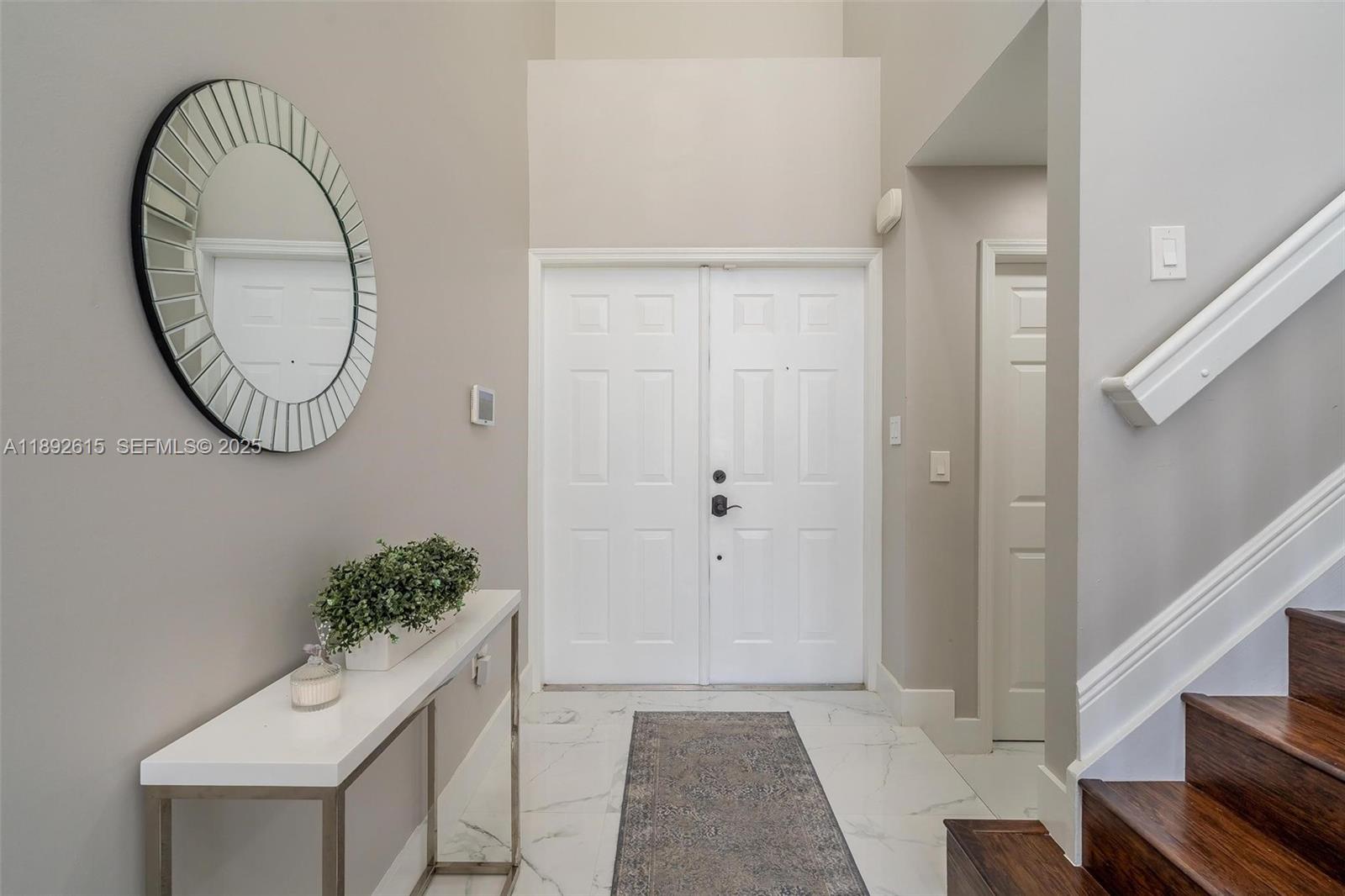 15025 Southwest 141st Terrace Miami, FL 33196 - Photo 9 of 34 a view of an entryway with wooden floor and mirror