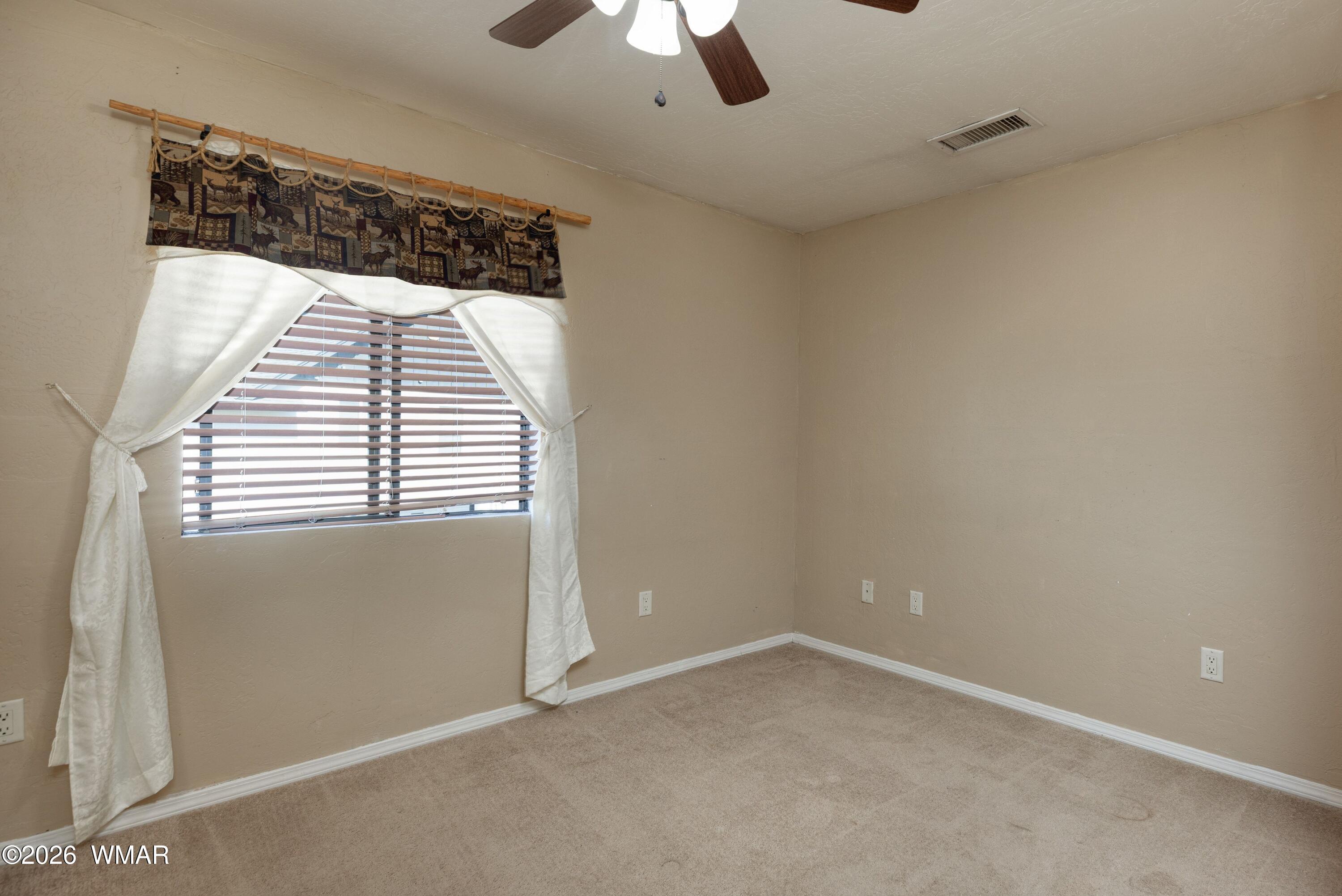 2722 Bain Trail Overgaard, AZ 85933 - Photo 8 of 28 an empty room with a window and chandelier fan