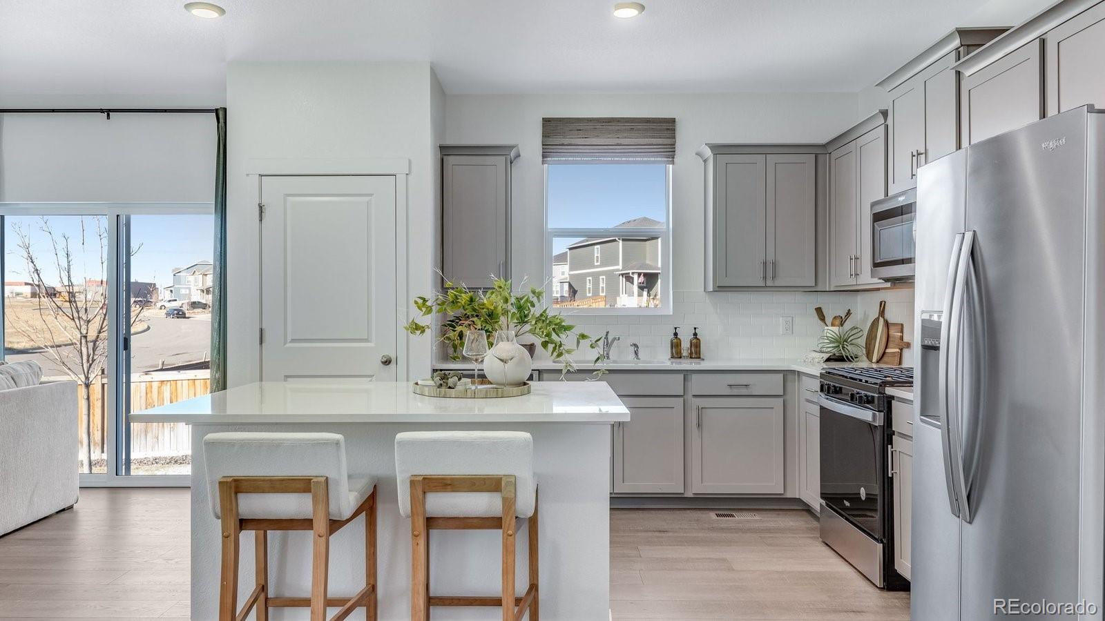 799 Ayrshire Road Johnstown, CO 80534 - Photo 12 of 36 a kitchen with stainless steel appliances granite countertop a white cabinets and a refrigerator