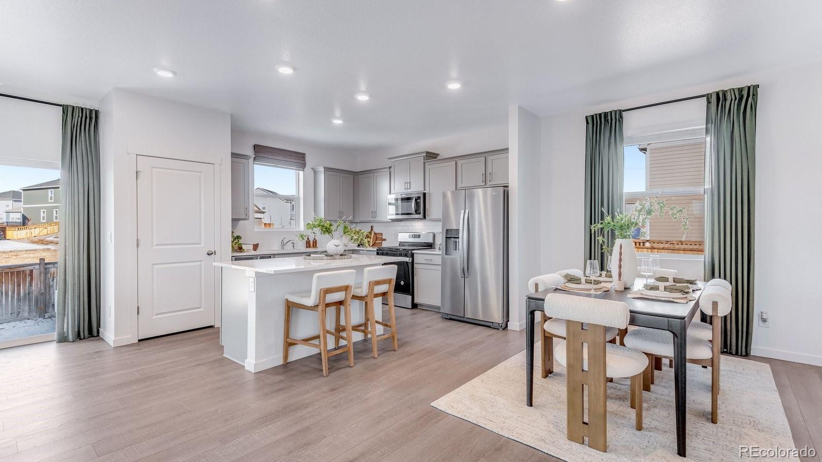 799 Ayrshire Road Johnstown, CO 80534 - Photo 8 of 36 a kitchen with white cabinets and stainless steel appliances