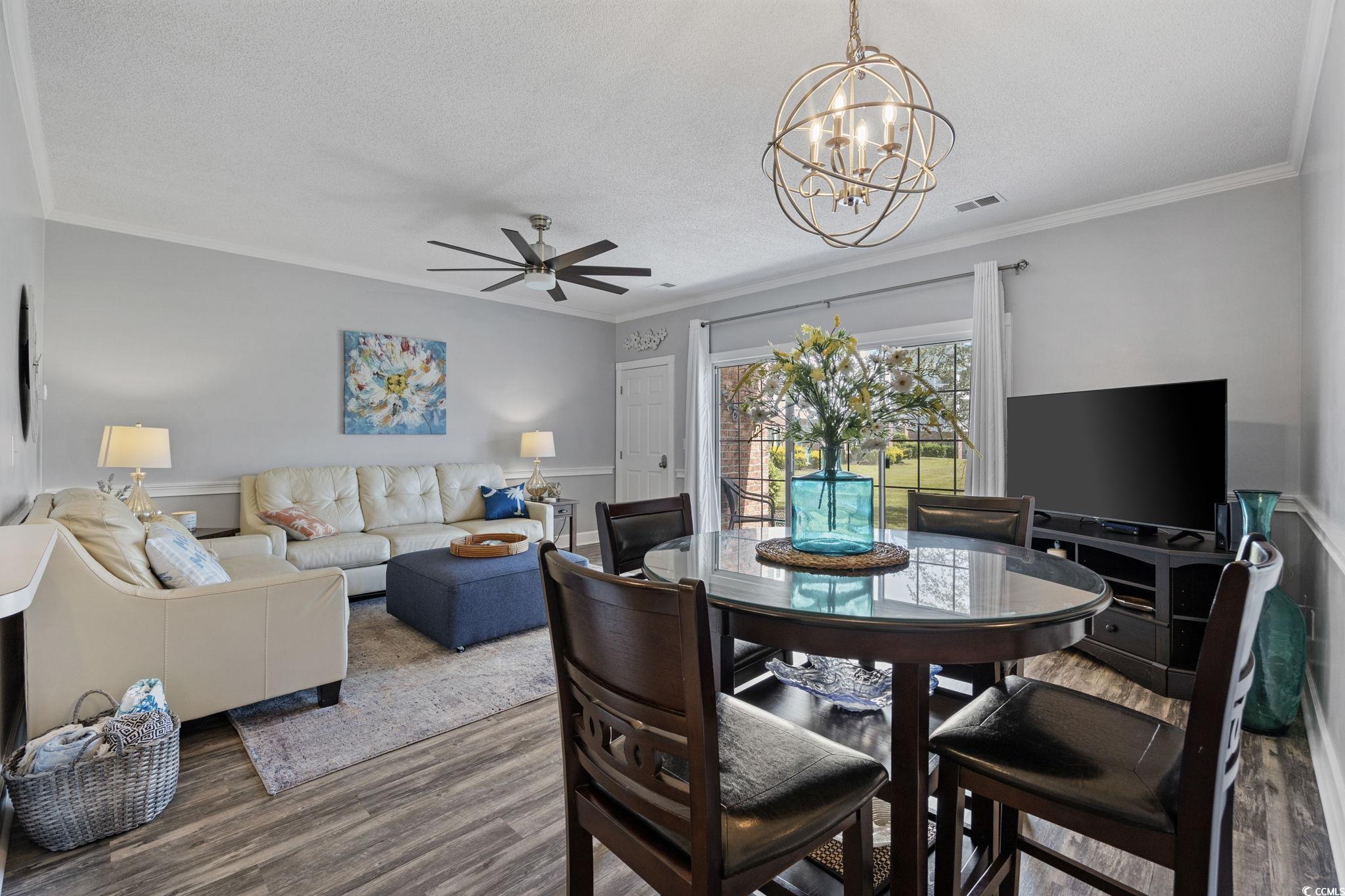 4846 Carnation Circle, Unit 103 Myrtle Beach, SC 29577 - Photo 11 of 31 Dining room with ornamental molding, ceiling fan, wood finished floors, a chandelier, and a textured ceiling