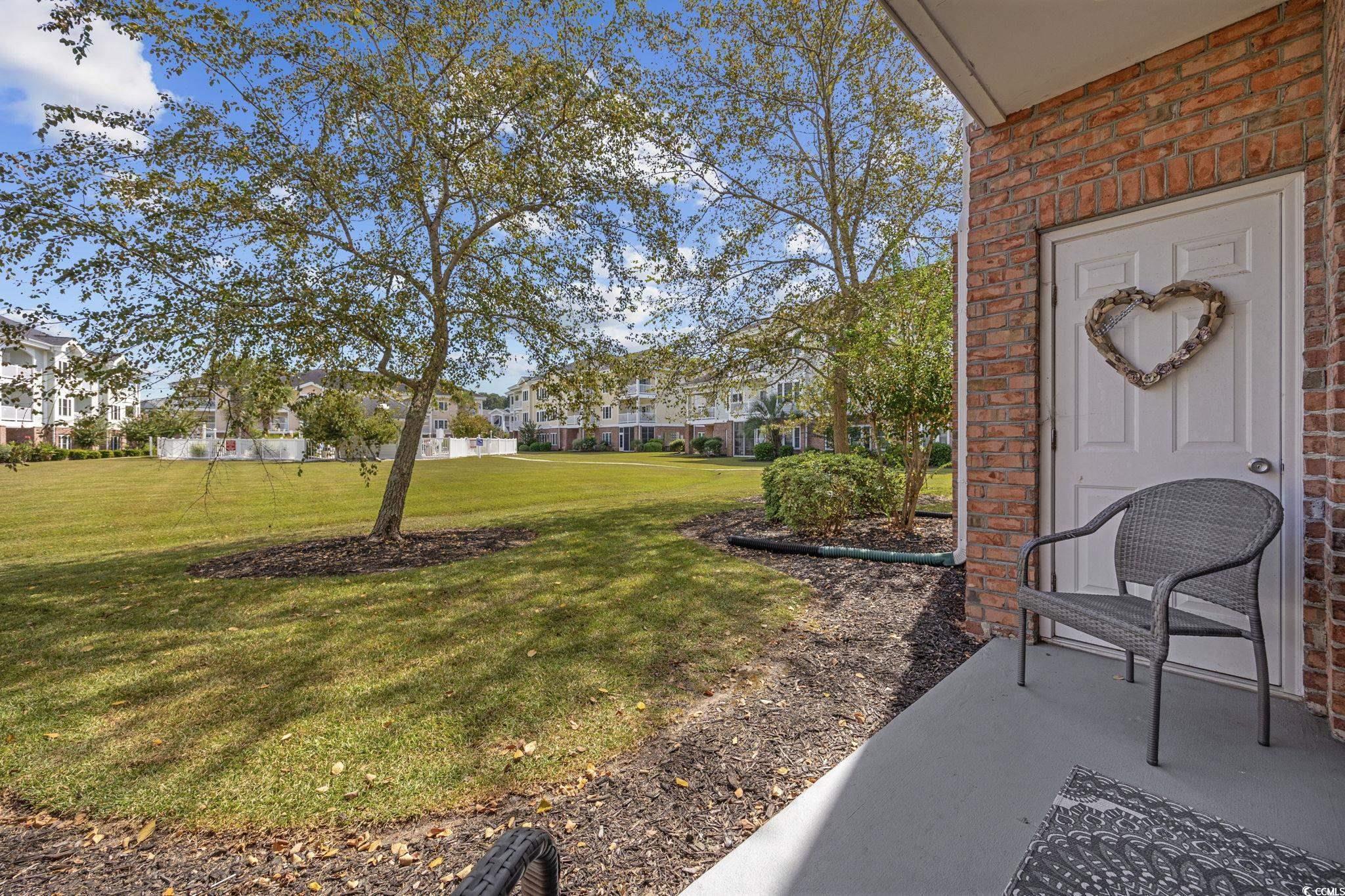 4846 Carnation Circle, Unit 103 Myrtle Beach, SC 29577 - Photo 18 of 31 View of green lawn with a residential view