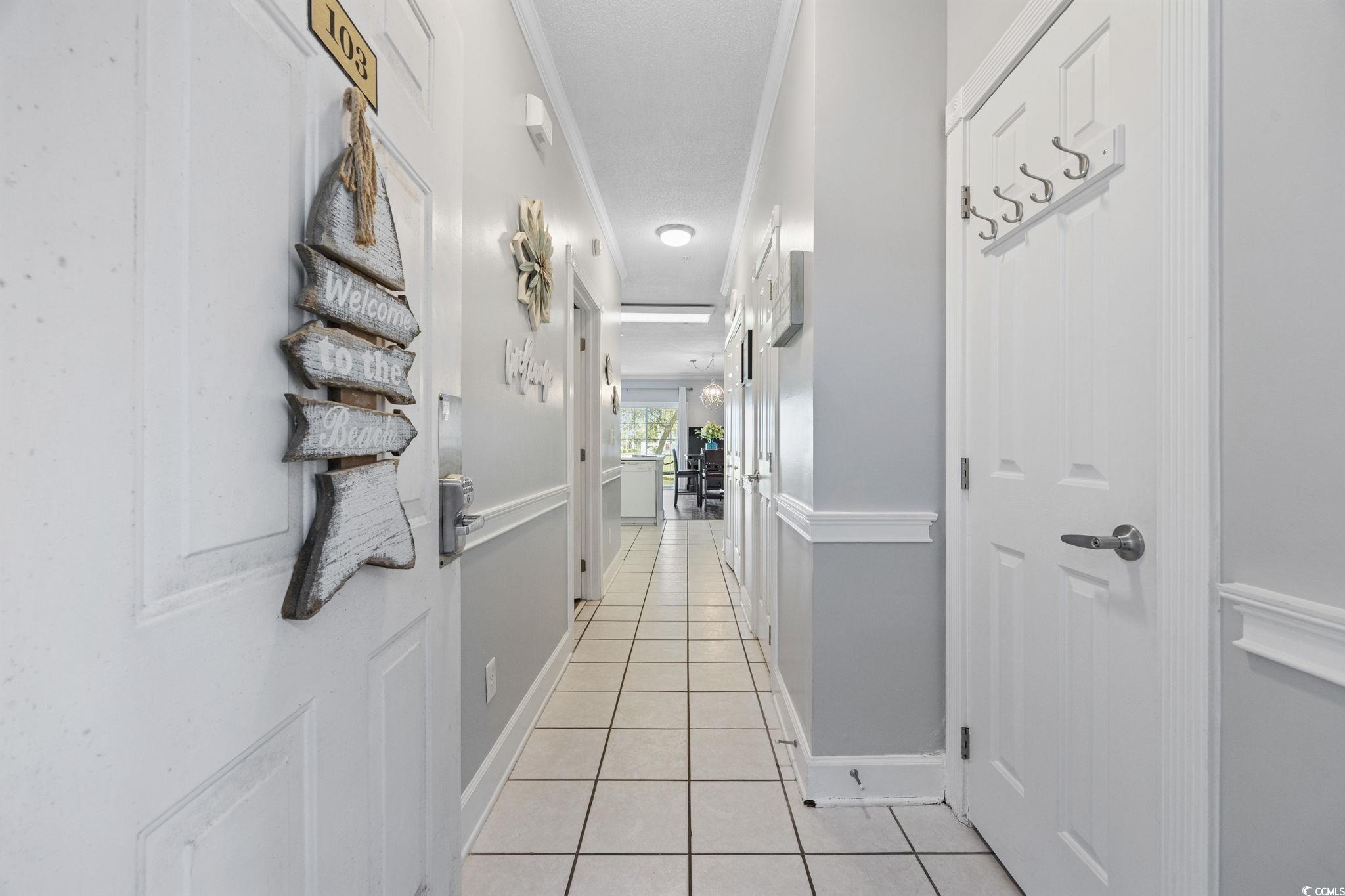 4846 Carnation Circle, Unit 103 Myrtle Beach, SC 29577 - Photo 2 of 31 Corridor featuring light tile patterned floors and ornamental molding