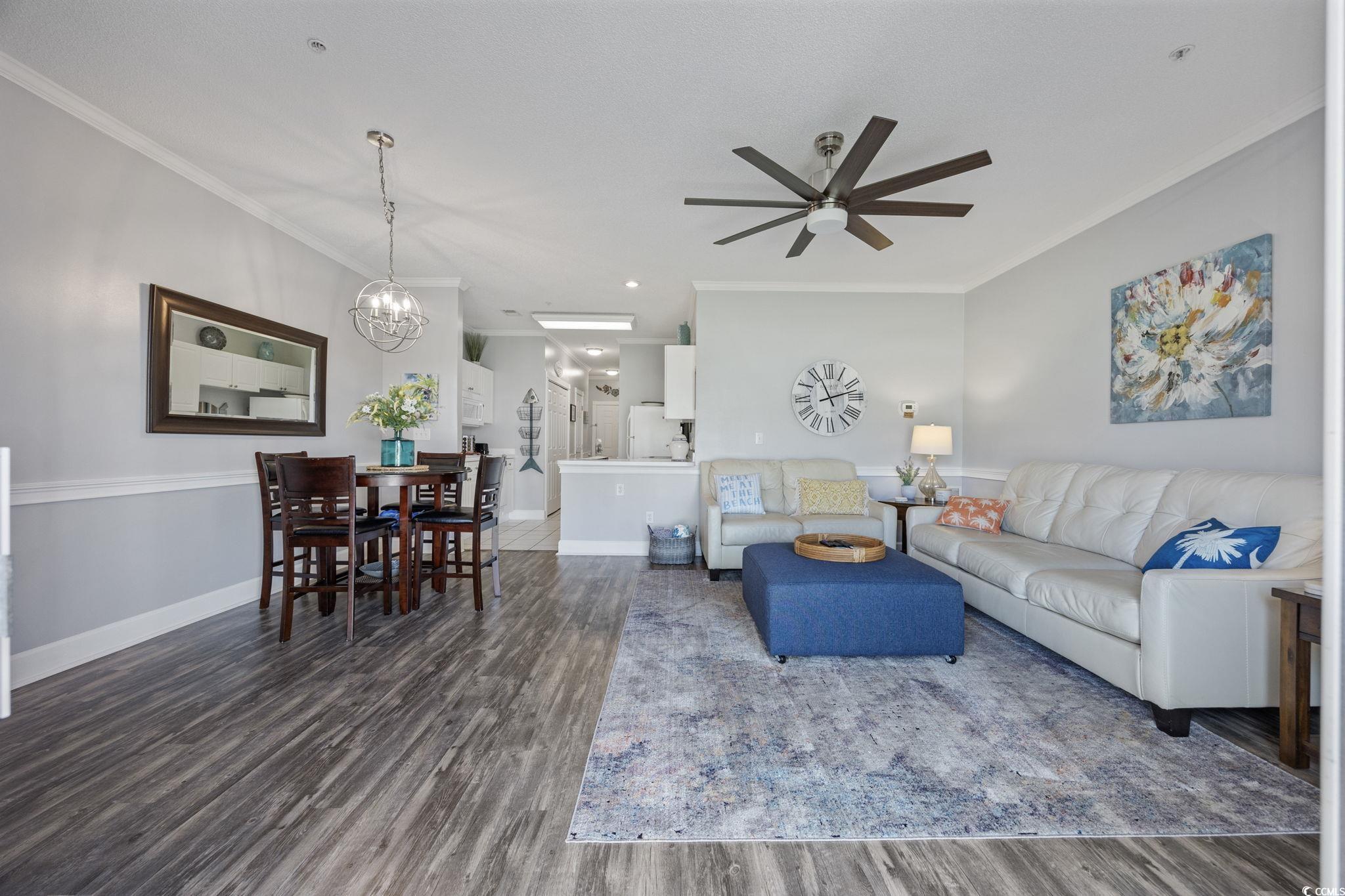 4846 Carnation Circle, Unit 103 Myrtle Beach, SC 29577 - Photo 3 of 31 Living room featuring dark wood-style flooring, crown molding, a chandelier, and ceiling fan