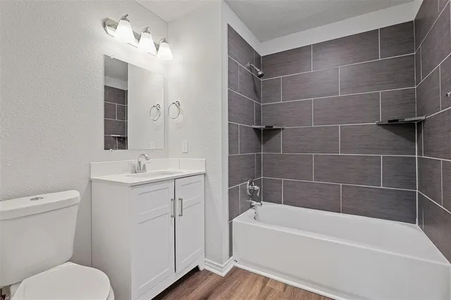a bathroom with a sink toilet vanity and bathtub