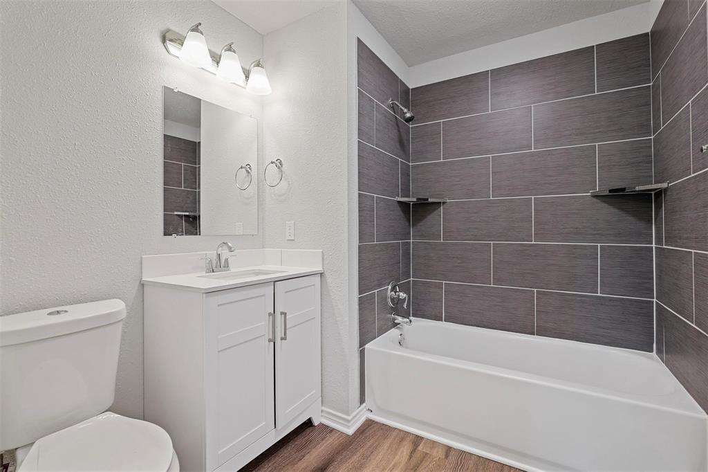 317 Jones Street Bonham, TX 75418 - Photo 11 of 15 Full bath featuring shower / tub combination, wood finished floors, vanity, and a textured wall