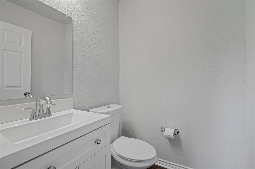 317 Jones Street Bonham, TX 75418 - Photo 12 of 15 Half bath with a textured wall and vanity