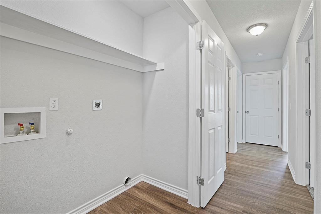 317 Jones Street Bonham, TX 75418 - Photo 13 of 15 Washroom with gas dryer hookup, dark wood-type flooring, a textured ceiling, hookup for a washing machine, and electric dryer hookup