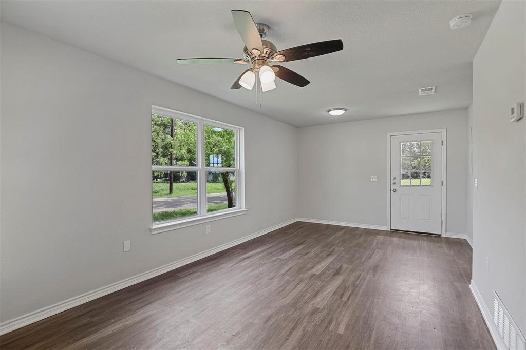 317 Jones Street Bonham, TX 75418 - Photo 4 of 15 Empty room with dark wood-style flooring and a ceiling fan