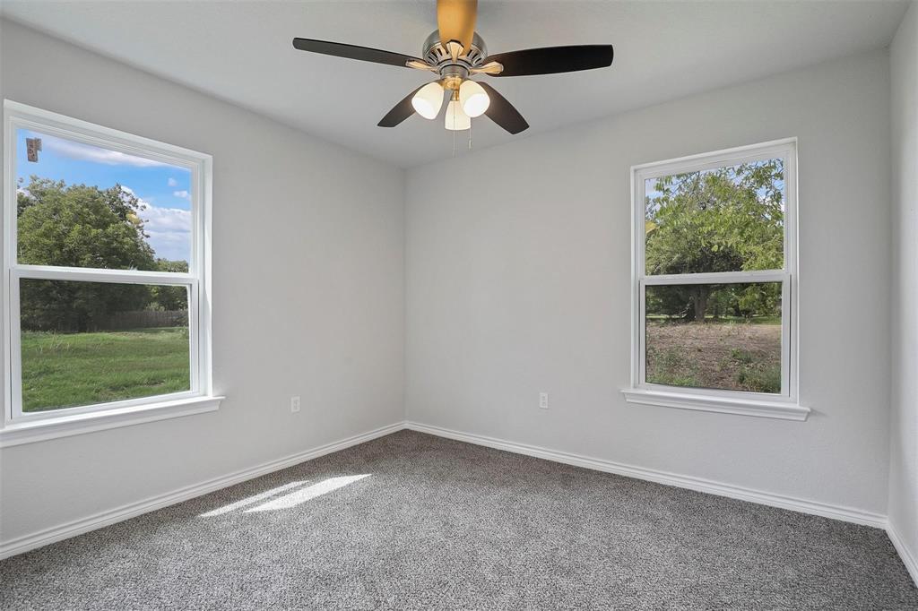 317 Jones Street Bonham, TX 75418 - Photo 9 of 15 Carpeted empty room with plenty of natural light and a ceiling fan