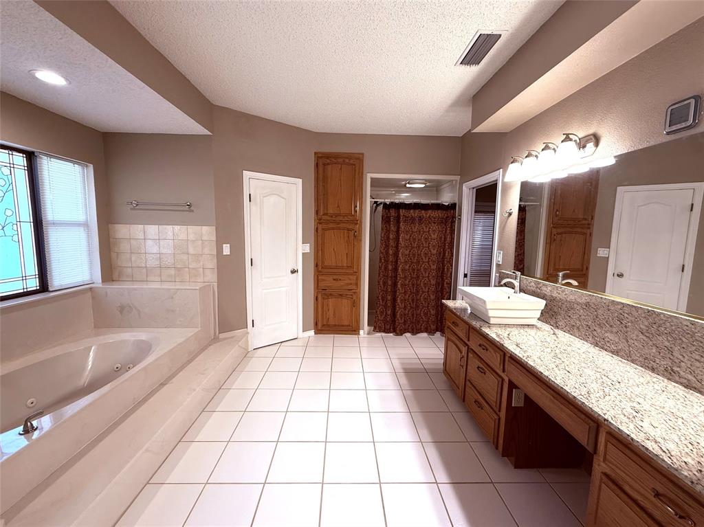 12098 Squirrel Road Pittsburg, TX 75686 - Photo 19 of 37 a bathroom with a granite countertop sink mirror and shower