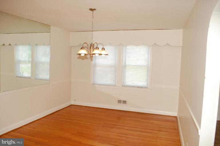 1660 Northbourne Road Baltimore, MD 21239 - Photo 2 of 11 wooden floor in an empty room with a window