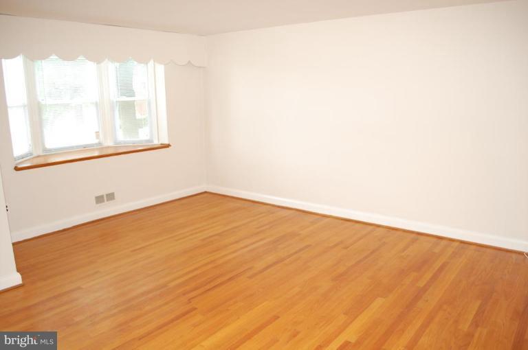 1660 Northbourne Road Baltimore, MD 21239 - Photo 3 of 11 a view of empty room with wooden floor and fan