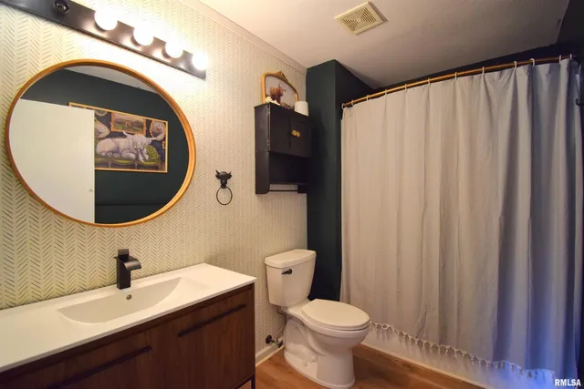 a bathroom with a toilet a sink and a mirror