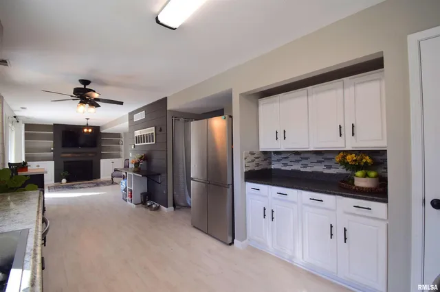 a kitchen with stainless steel appliances kitchen island granite countertop a refrigerator and a stove top oven