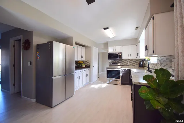 a kitchen with stainless steel appliances a refrigerator a stove a sink a counter space and cabinets