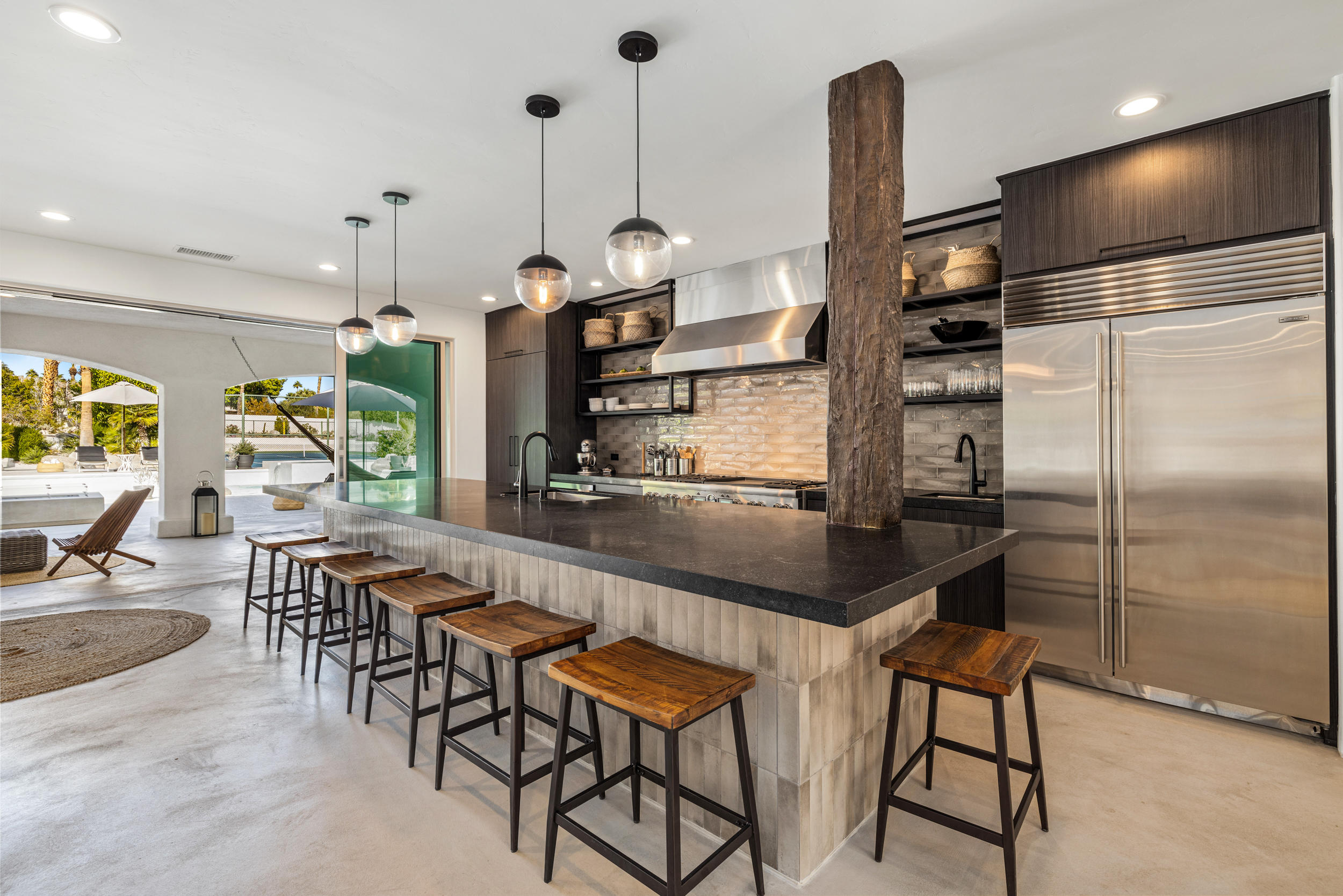 594 West Stevens Road, Unit A Palm Springs, CA 92262 - Photo 6 of 133 a kitchen with stainless steel appliances kitchen island a table and chairs in it