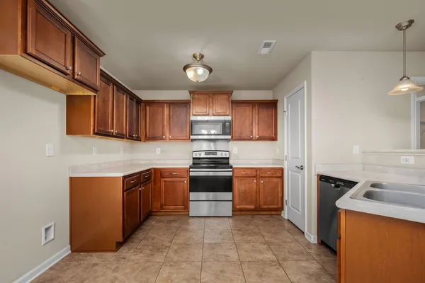 a kitchen with stainless steel appliances granite countertop a stove top oven a sink and dishwasher