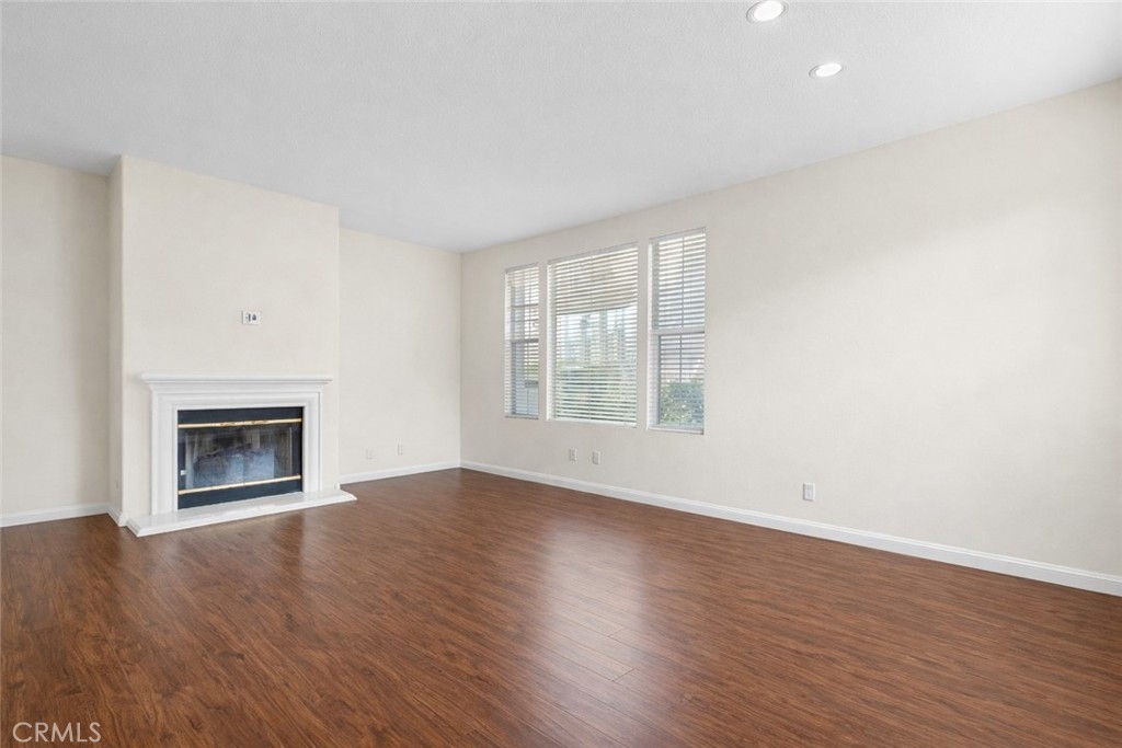9 Diamant Way Aliso Viejo, CA 92656 - Photo 7 of 33 an empty room with wooden floor fireplace and windows
