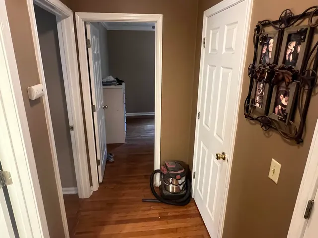 a view of a hallway with wooden floor and stairs