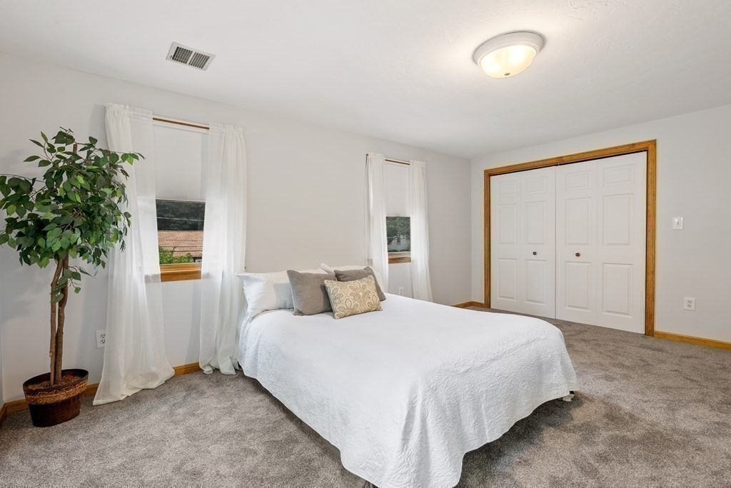 12 Cypress Road Natick, MA 01760 - Photo 24 of 41 a bedroom with a bed and a potted plant
