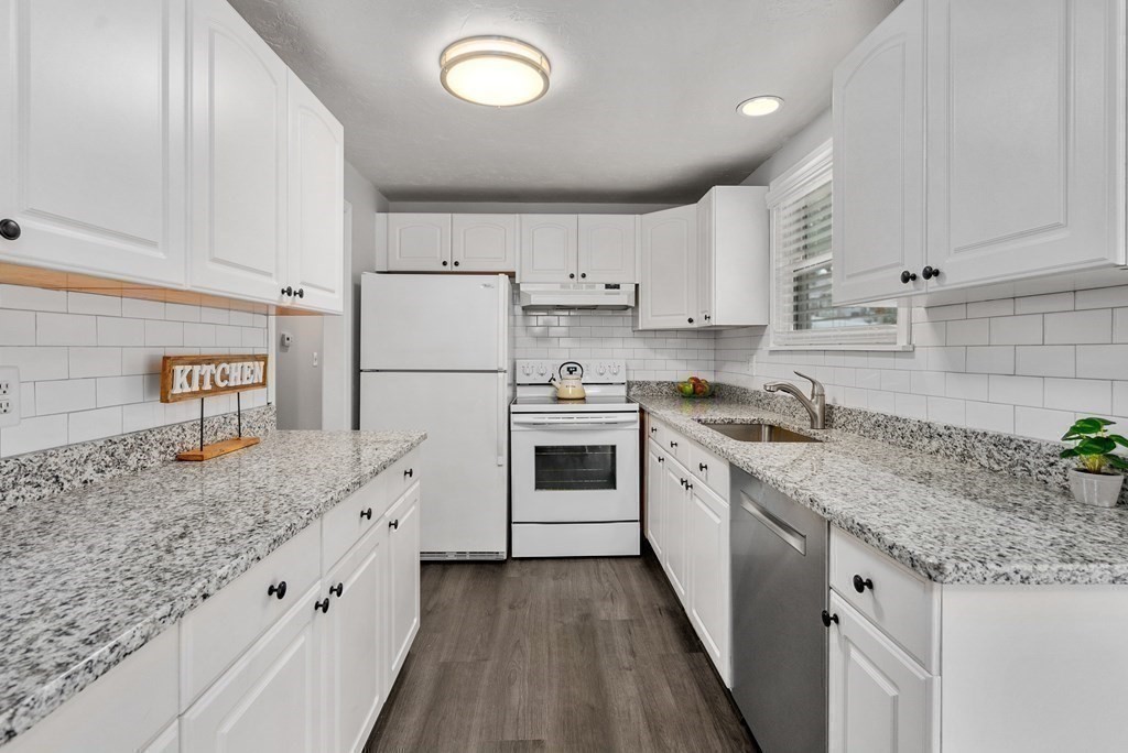 12 Cypress Road Natick, MA 01760 - Photo 8 of 41 a kitchen with granite countertop white cabinets and white appliances