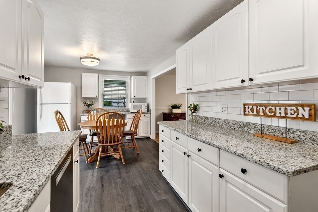 12 Cypress Road Natick, MA 01760 - Photo 9 of 41 a kitchen with stainless steel appliances granite countertop a table chairs sink and cabinets