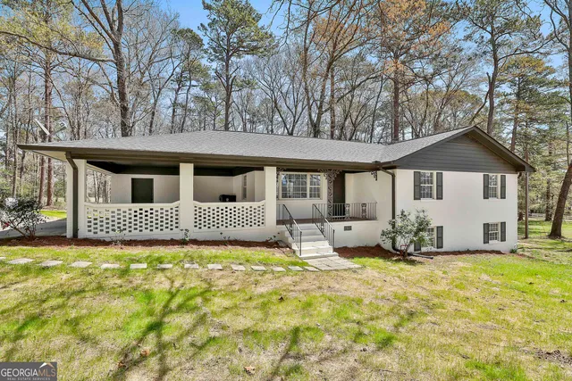 a front view of house with yard and trees in the background