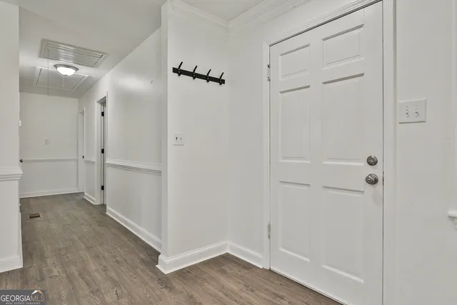 a kitchen with stainless steel appliances granite countertop a refrigerator a sink dishwasher a stove and white countertops with wooden floor