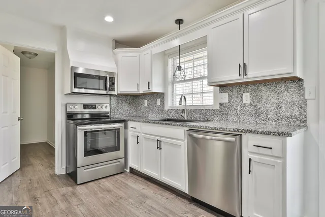 a kitchen with stainless steel appliances granite countertop a refrigerator stove and oven