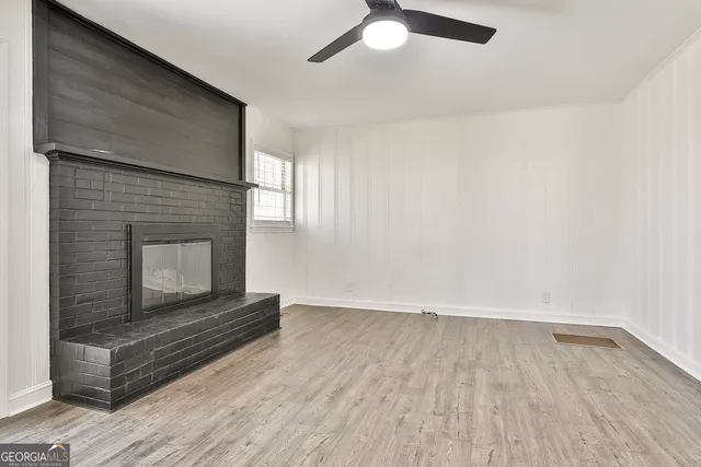 a living room with stainless steel appliances furniture a fireplace and wooden floor