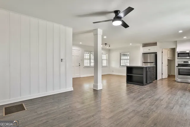 a view of a room with wooden floor and white walls