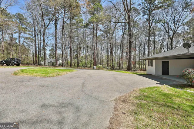 a view of a house with a big yard and large trees