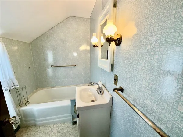 a bathroom with a tub a sink and a mirror