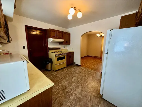 a kitchen with stainless steel appliances granite countertop a refrigerator a stove and a sink