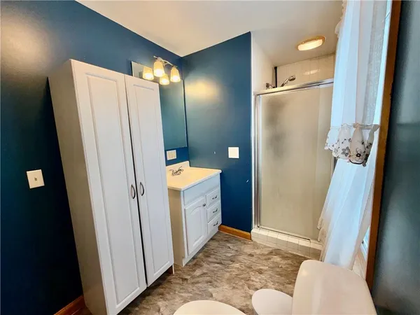 a bathroom with a sink toilet and shower