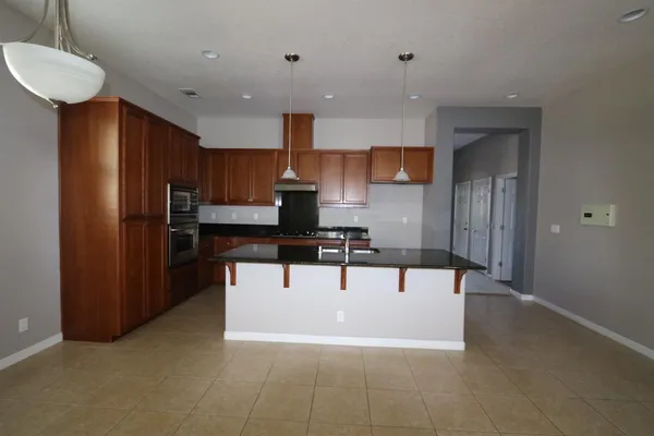 a view of kitchen with stainless steel appliances kitchen island microwave and cabinets