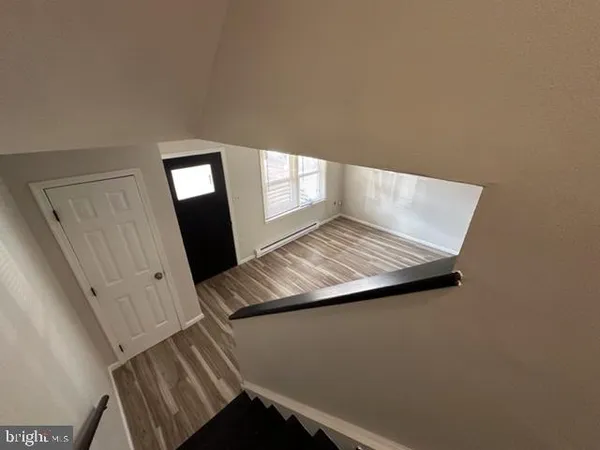 a view of empty room with wooden floor