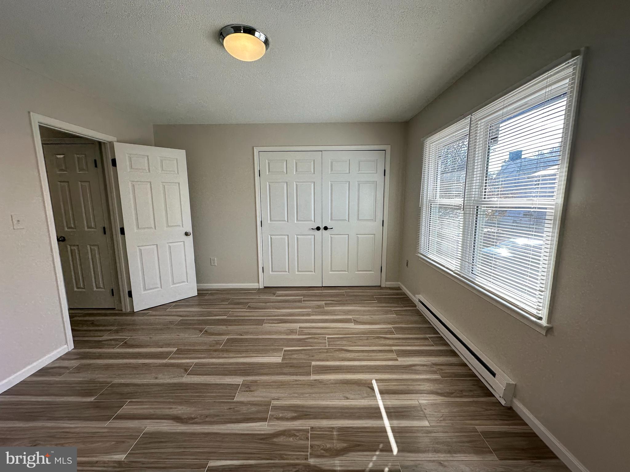 107 North Church Street Charles Town, WV 25414 - Photo 22 of 26 a view of an empty room with wooden floor and a window