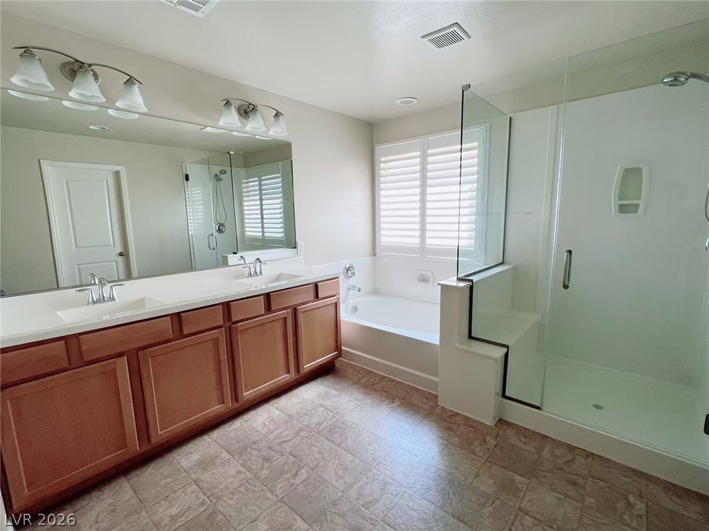 146 Tree Shot Court Las Vegas, NV 89113 - Photo 15 of 18 Double vanity and a deep soaking tub create a luxurious primary bathroom retreat.