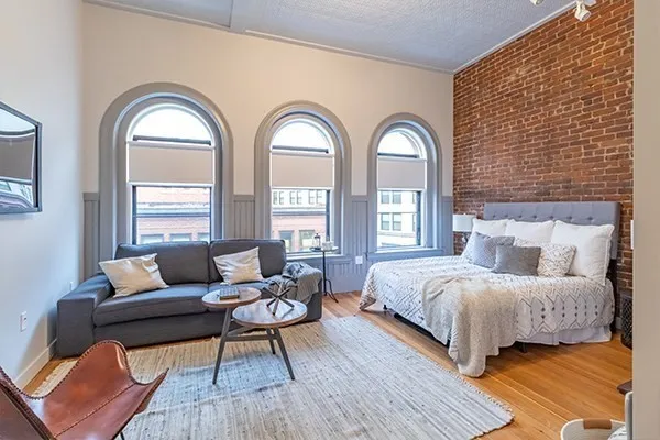 a bedroom with a bed and windows