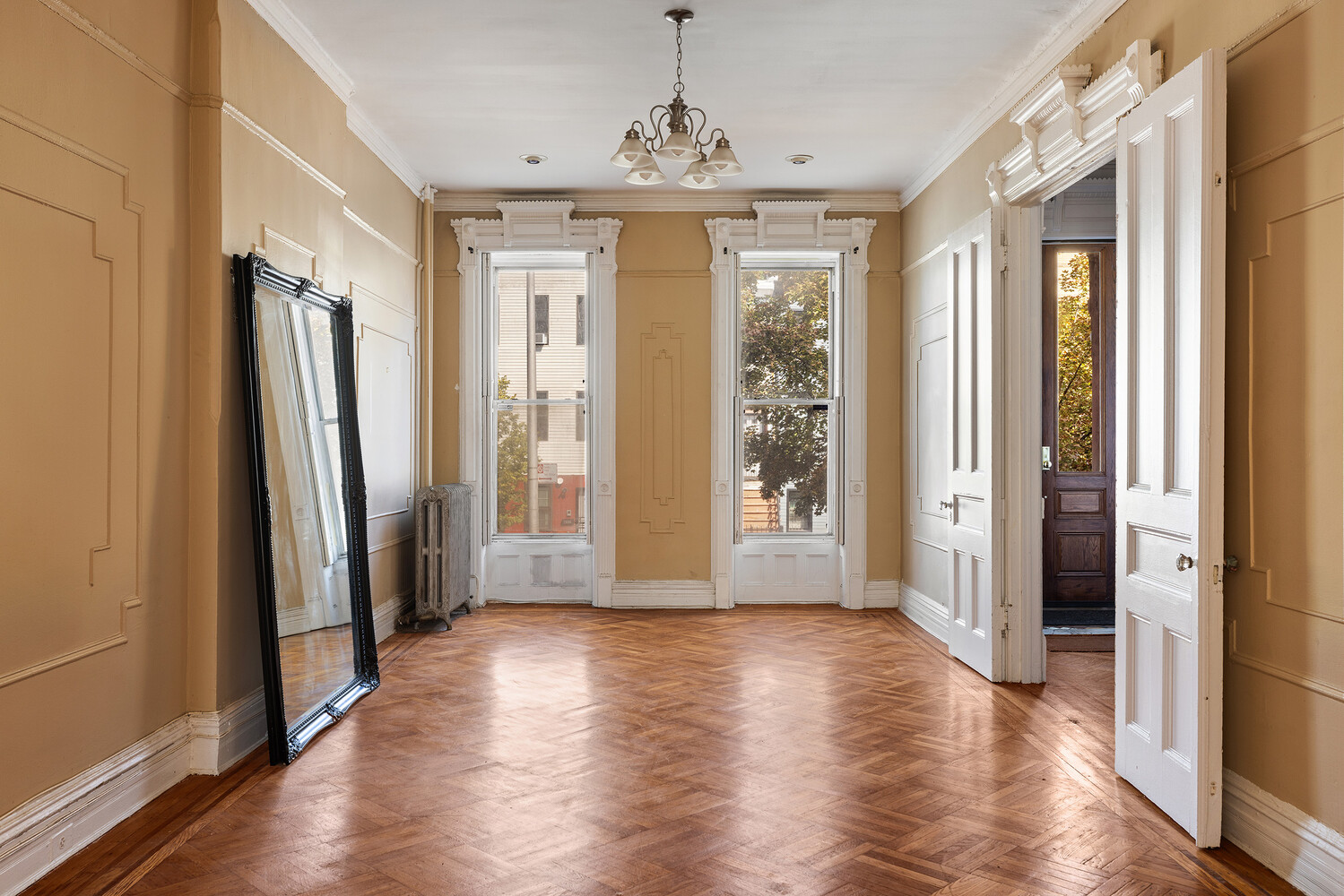 a view of a hallway with wooden floor and windows