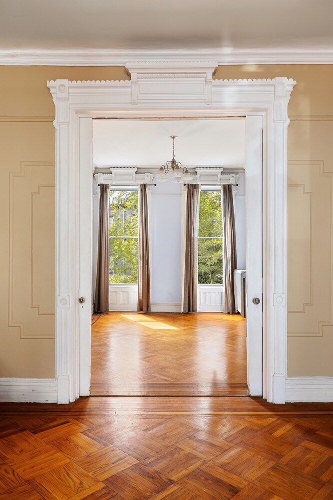 490 Monroe Street Brooklyn, NY 11221 - Photo 7 of 15 a view of a hallway with wooden floor and a fireplace