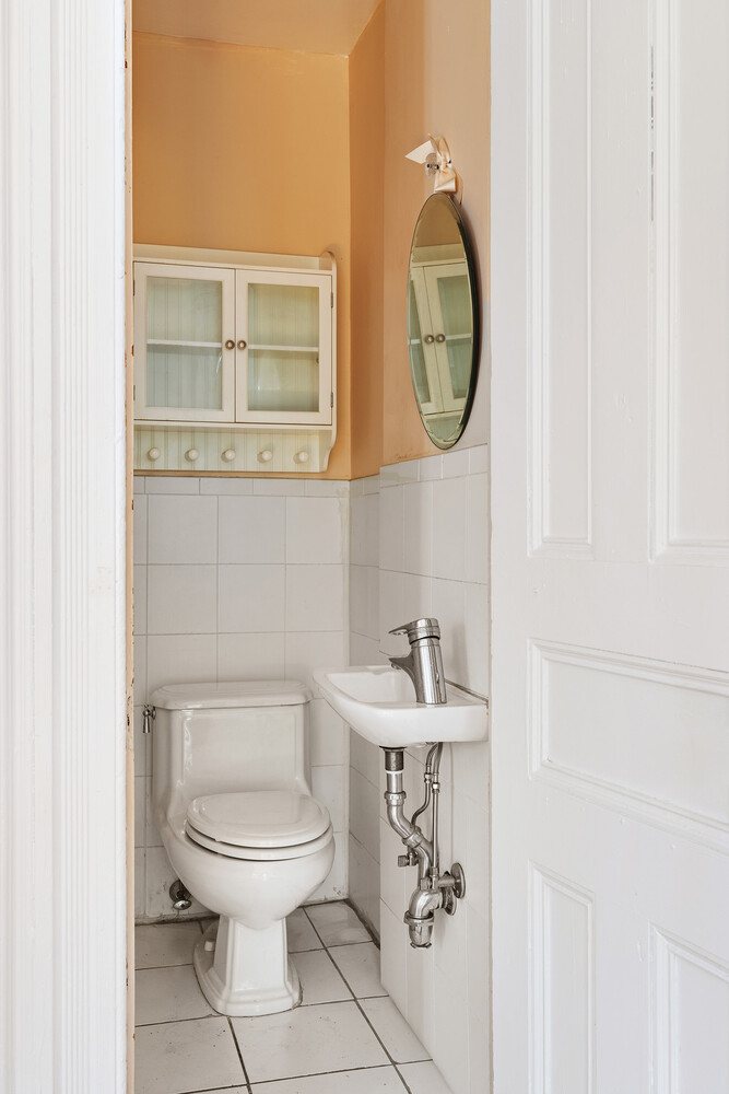 490 Monroe Street Brooklyn, NY 11221 - Photo 8 of 15 a bathroom with a toilet sink a mirror and vanity