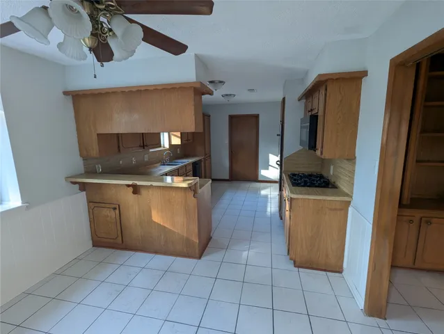 a kitchen with a sink a stove top oven and cabinets