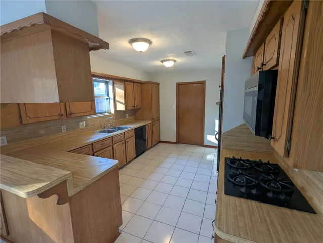 a kitchen with stainless steel appliances a stove a sink and a refrigerator